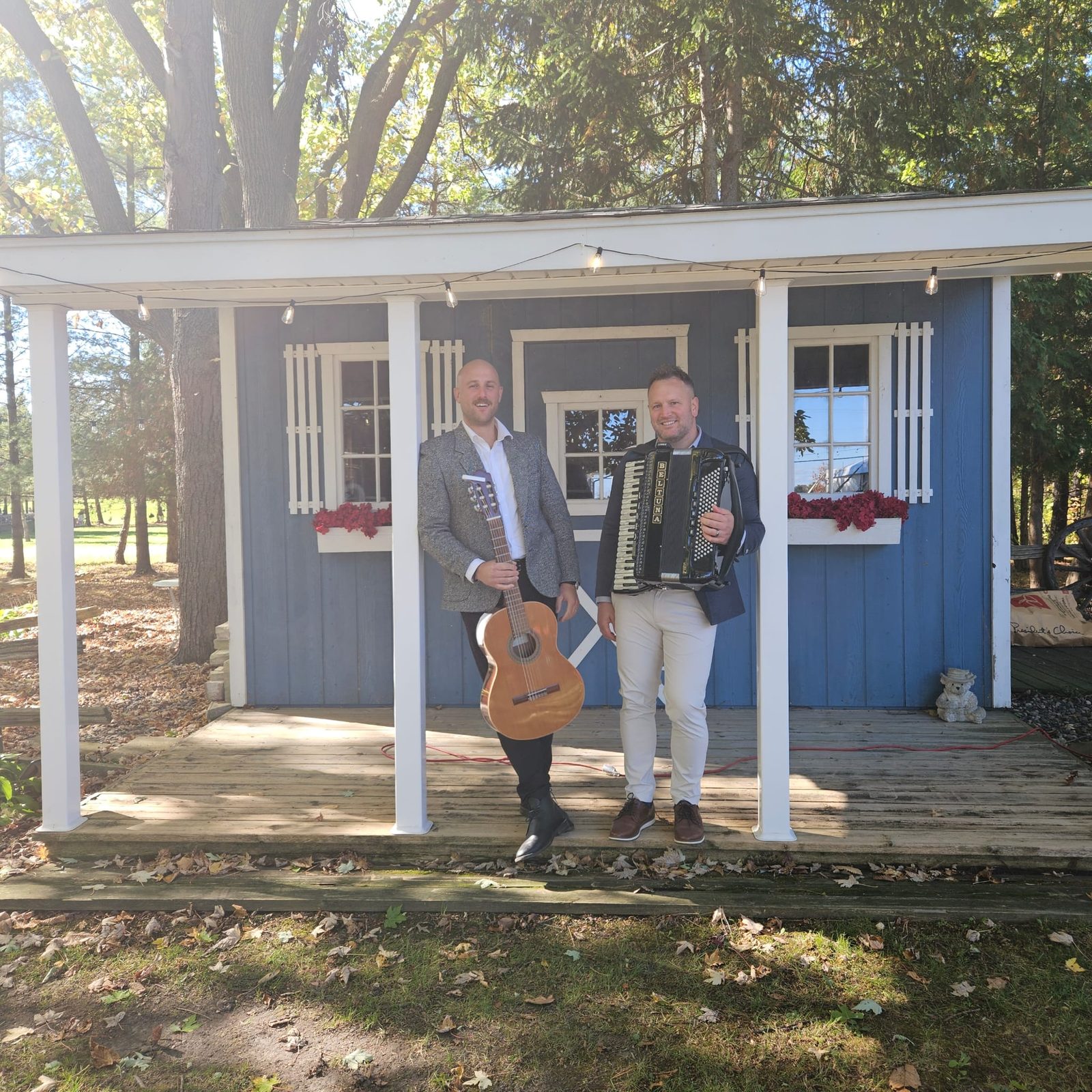 The duo with guitar and accordion on a cottage porch