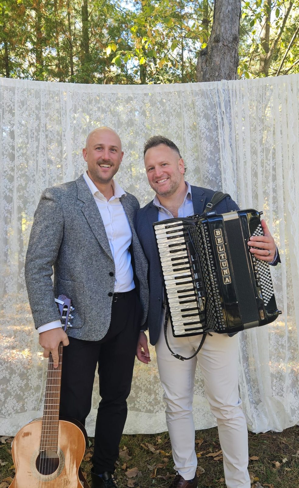 The two members of Old Europe Band holding a guitar and an accordion